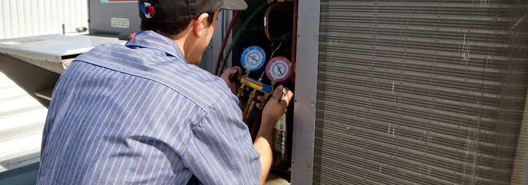 HVAC technician servicing a condenser unit in Altamont