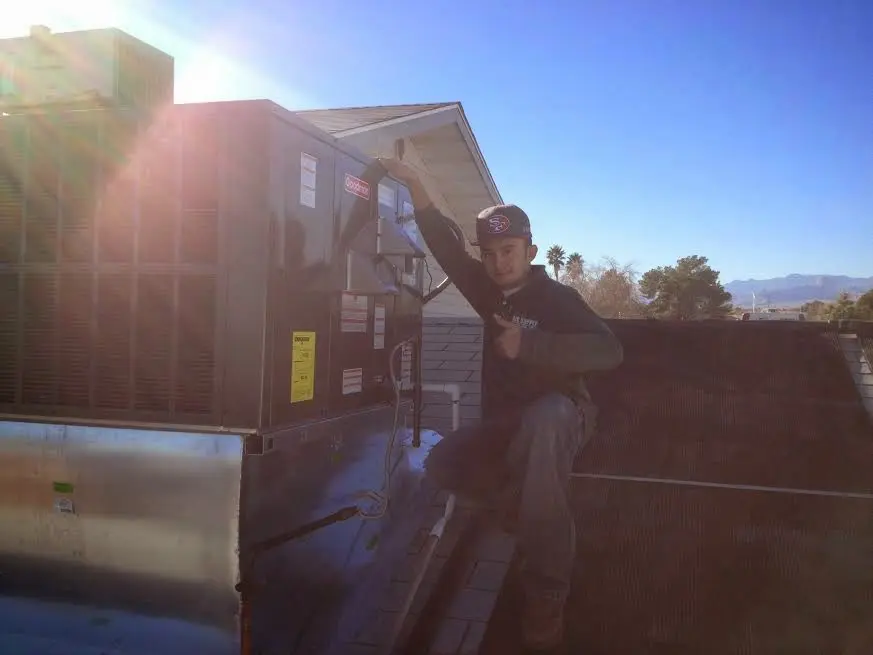 HVAC technician performing Heat Pump Repair on a rooftop unit in Altamont